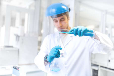 Scientist doctor using laboratory flask for taking samples from test tube and comparing resultsの写真素材