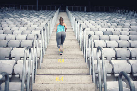 Female fitness trainer working out on stairs, training and doing exercisesの写真素材