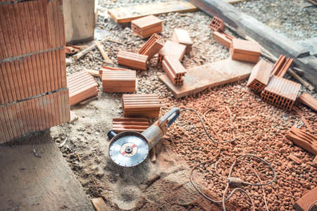 Industrial construction site tools, angle grinder used for cutting bricks at building renovation, reconstructionの写真素材