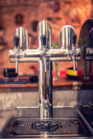 Beer taps at restaurant bar pub or bistro. Closeup details of beer draft taps in a row on barman counter in barの写真素材