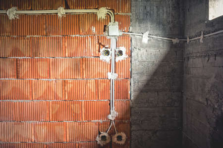 electric lines construction at new estate electricity pipes and brick walls under constructionの写真素材