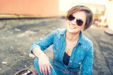 Trendy brunette girl, smiling and laughing against orange background, isolated. Hipster  girl smiling at camera, urban lifestyleの写真素材