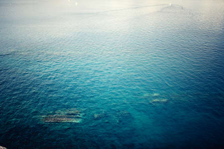 aerial view of clear ocean water, calm waves on a sunny day. Concept tranquill backgroundの写真素材