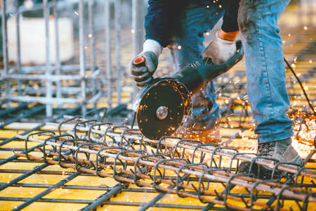 worker using an angle grinder for cutting steel, making sparks and debrisの写真素材