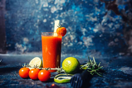spicy Bloody Mary cocktail served on a dark bar garnished with cherry tomatoesの写真素材