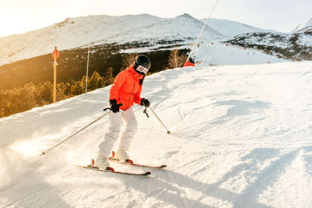 Skier on the slope in the mountains. Girl skiing on a sunny day