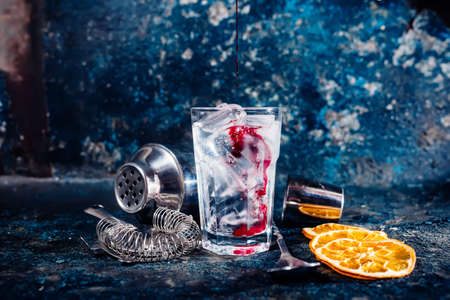 bartender pouring cranberry juice over vodka cocktailの写真素材