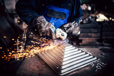 Professional worker using angle grinder for cutting and finishing steelの写真素材