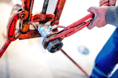 close-up of worker tightening pipes at plumbing installation