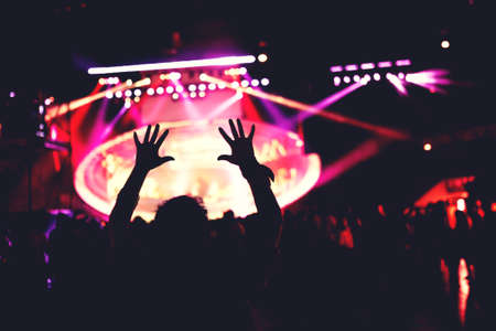 girl dancing silhouette. Live concert or music festival with crowd dancing in lights