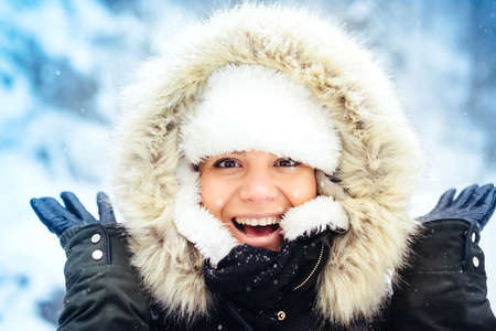 Outdoor portrait of happy, smiling woman, enjoying snow and winter days during cold season. Stylish portrait of beautiful womanの写真素材
