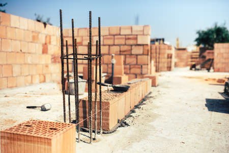 industrial construction site, placing bricks on cement while building exterior walls, industry detailsの写真素材
