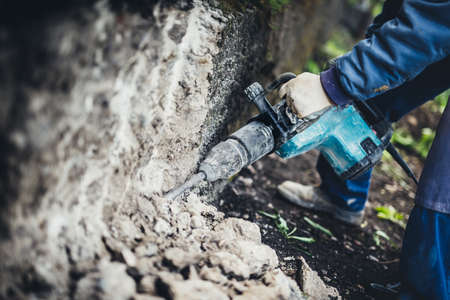 Industrial equipment close up. Construction worker using pneumatic machinery, drilling toolの写真素材