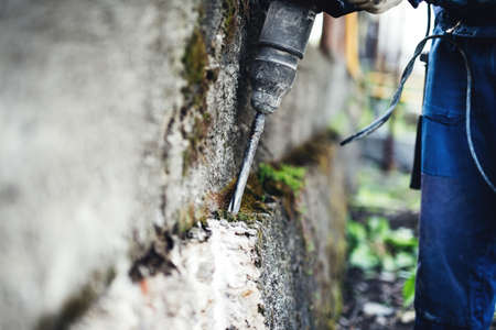 Working man practicing his skills with pneumatic drill at demolishing wallsの写真素材