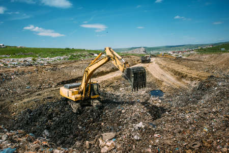 Excavator loader, bulldozer working in garbage dump. Recycling and resolving environmental issuesの写真素材