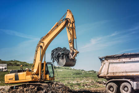 Industrial bulldozer and excavator working on site. 