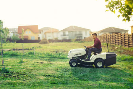 worker cutting grass with lawn mower, lawncare concept. Industrial details