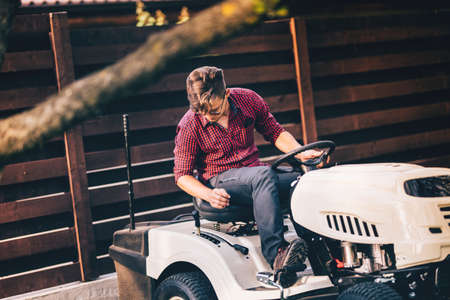 Professional gardner riding lawn mower - landscaping and gardening detailsの写真素材