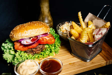 Tasty american foodporn -  beef burger with grilled meat and mayo served with fries, coleslaw and beerの写真素材