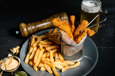 French fries and chicken tenders served as stylish dinner at restaurantの写真素材