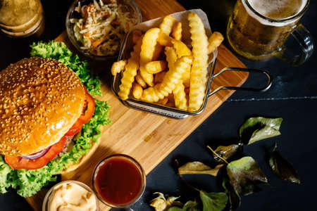 Close up, top view of freshly made beef burger with french fries and beerの写真素材