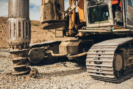 Rotary drills working and making holes in the ground on Highway construction site for viaduct and...