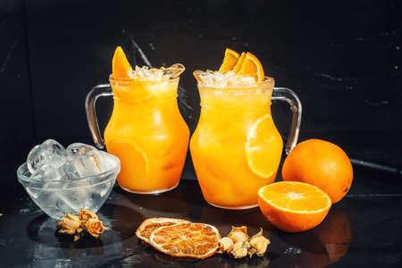 Fresh orange lemonade with ice and black backgroundの写真素材