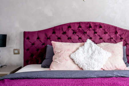 Close up of beautiful bed in elegant and comfortable modern bedroom with purple bedding. Interior design detailsの写真素材
