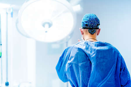 Artistic portrait of surgeon getting ready for surgery. Surgery scrubs, operating room and hospital detailsの写真素材