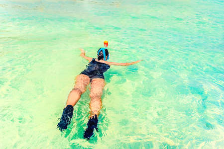 Young woman snorkeling in a tropical sea near sandy beachの写真素材