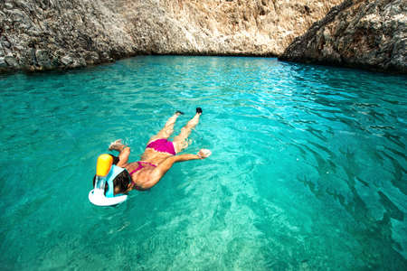 Woman enjoying snorkeling on a sunny day  on remote tropical islandの写真素材