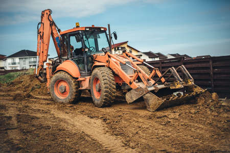 Construction site details with backhoe wheel loader excavator moving soil and earthの写真素材