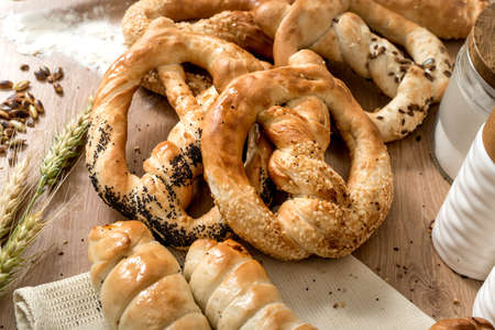 Sesame pretzels and different bakery products on wooden backgroundの写真素材