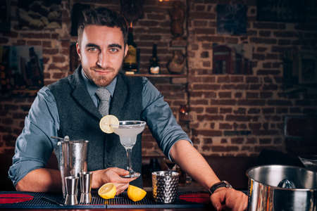 Portrait of beautiful barman making cocktails, signature margarita drink at local barの写真素材