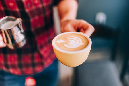 Professional bartender in coffee shop making fresh cappuccino and brewing coffeeの写真素材