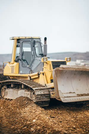 Industrial yellow bulldozer leveling earth