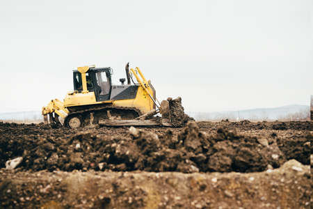 mini industrial bulldozer moving dirt and earth with scoop. Industrial details of landscapingの写真素材