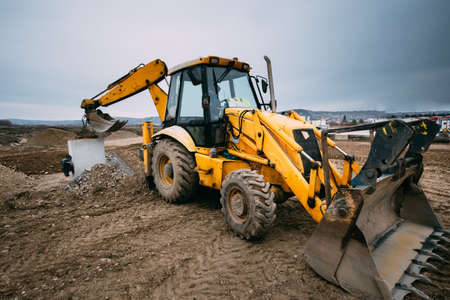 close up details of massive working machinery, industrial backhoe loader with excavator on construction siteの写真素材
