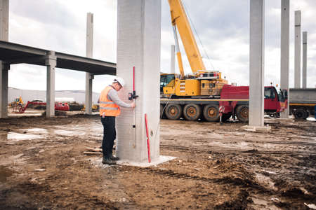 survey engineer in prefabricated construction site using special equipment for surveying