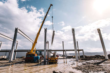 Process of unloading cargo using crane, industrial cement cast prefabricated beams and pillarsの写真素材