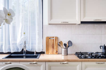 Elegant black sink in modern luxurious kitchen with white wooden furnitureの写真素材