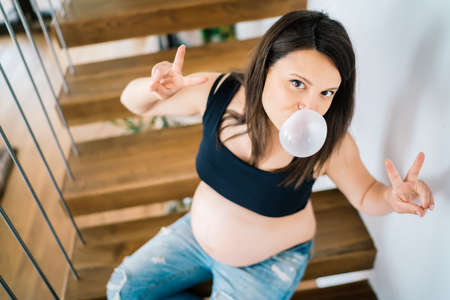 beautiful pregnant woman chewing bubble gum and having funの写真素材