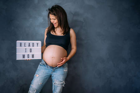 pregnancy, motherhood, parents and expectation concept. happy woman in studio