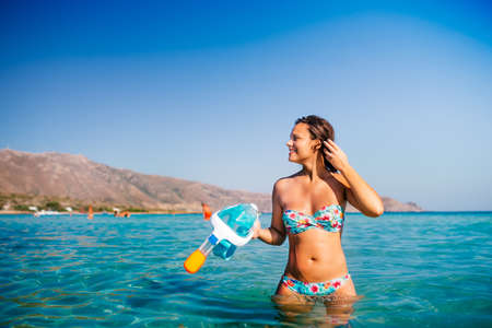 Summer portrait of woman preparing for scubadiving, snorkeling with mask and underwater gear. Swimming, ocean and sea conceptの写真素材