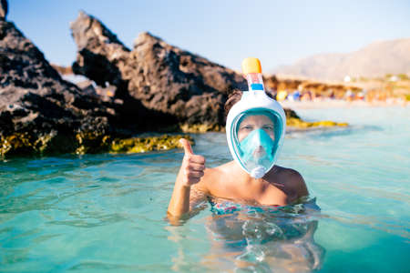 Portait of woman in bikini enjoying snorkeling during summertime on tropical islandの写真素材