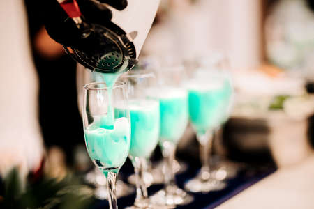 Barman pouring and mixing professional cocktails. Details of alcoholic drinks and beverages at pub...