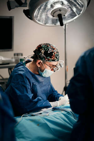 Details of surgeon performing invasive surgery in hospital roomの写真素材