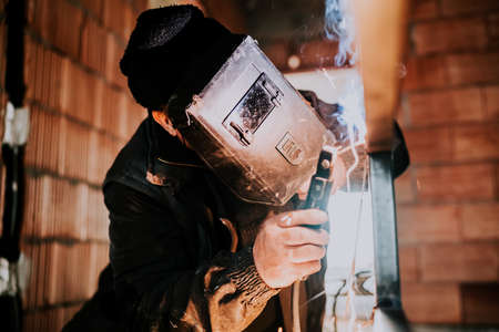 Close up of industrial worker welding metal structureの写真素材