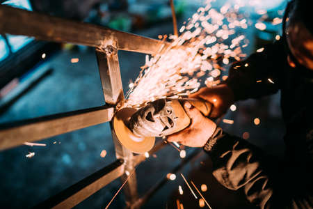 man working in construction industry and cutting metal with disc angle grinderの写真素材