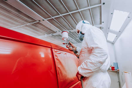 Details of automotive engineer, mechanic painting a red car in workshopの写真素材
